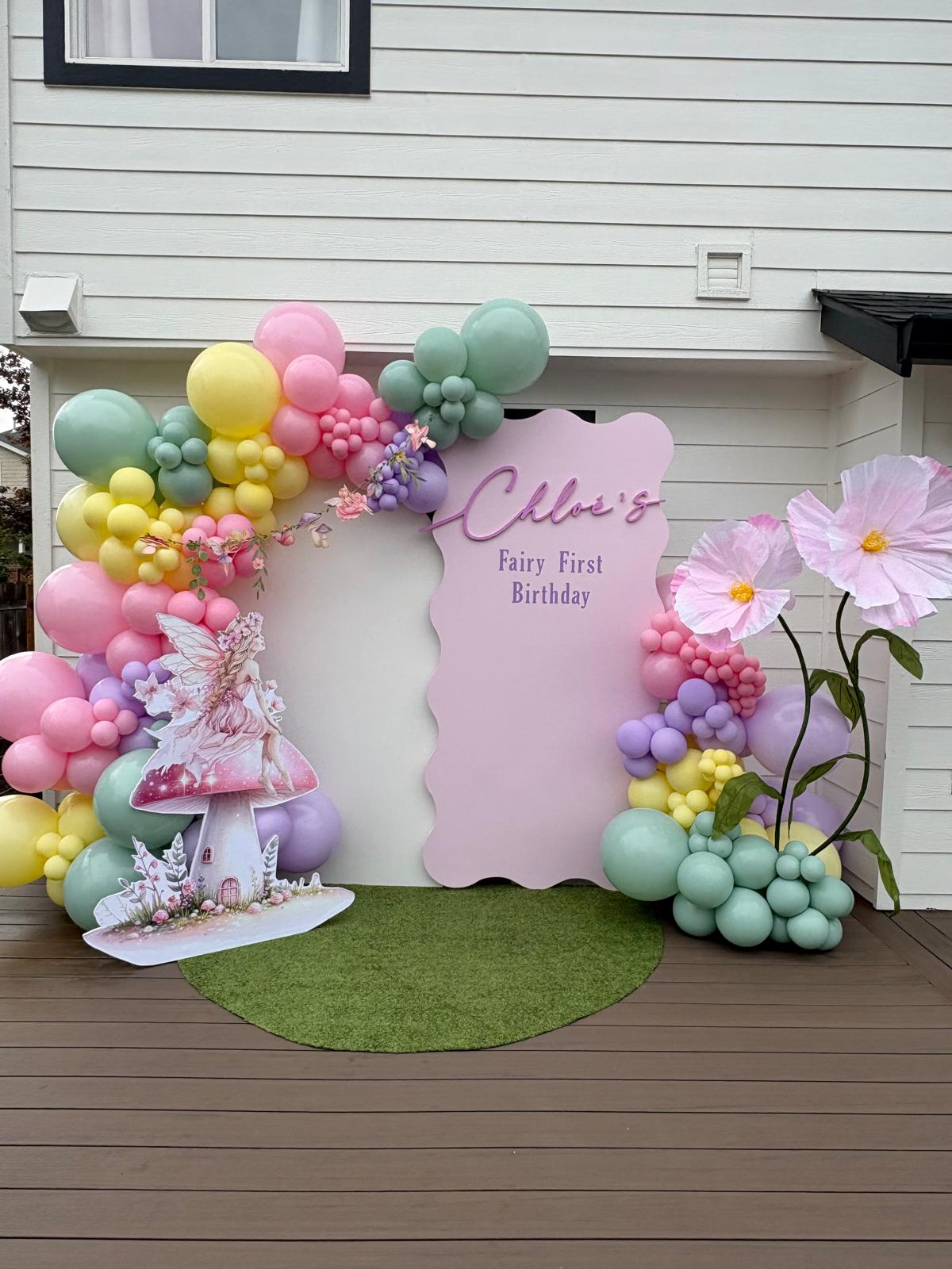 Pastel fairy first birthday backdrop with balloons, florals, and custom decorations