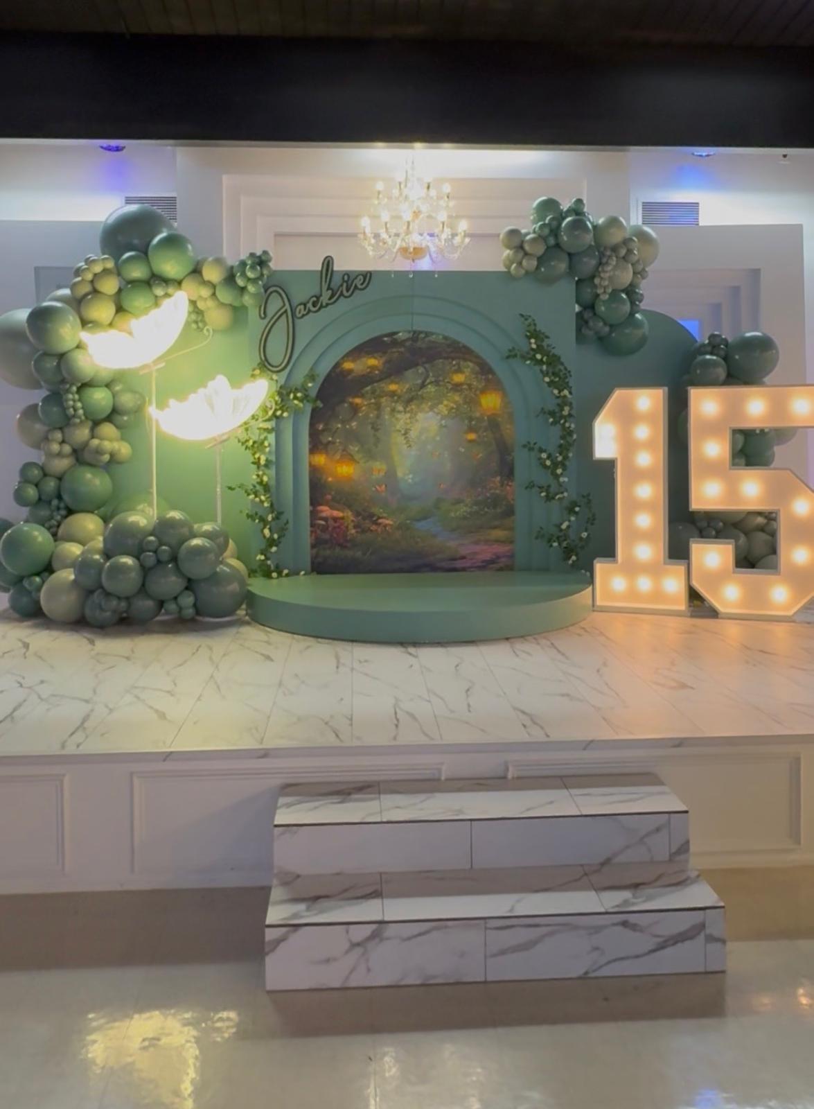 Elegant green balloon installation with illuminated marquee numbers